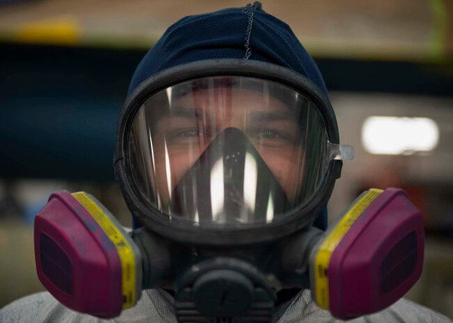 A civilian wears a full mask respirator while standing for a photo.