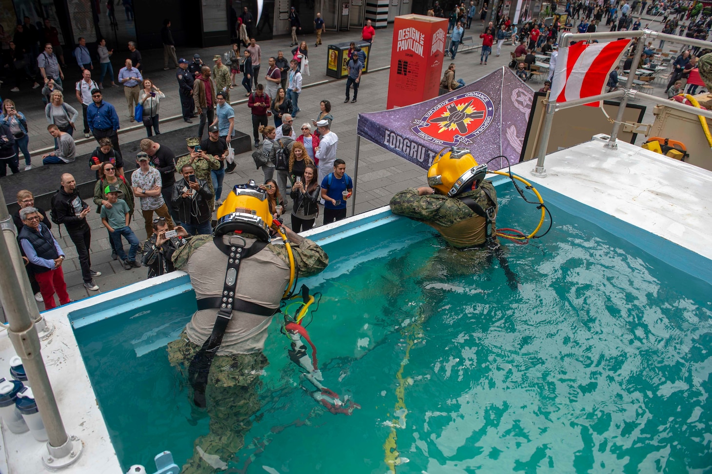 Two U.S. Navy divers pose for photos during a diving demonstration in Times Square as a part of Fleet Week New York.