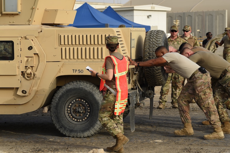 A fire team works together to push a Humvee as part of the Police Week 2019 fire team challenge May 12, 2019, at Al Dhafra Air Base, United Arab Emirates.