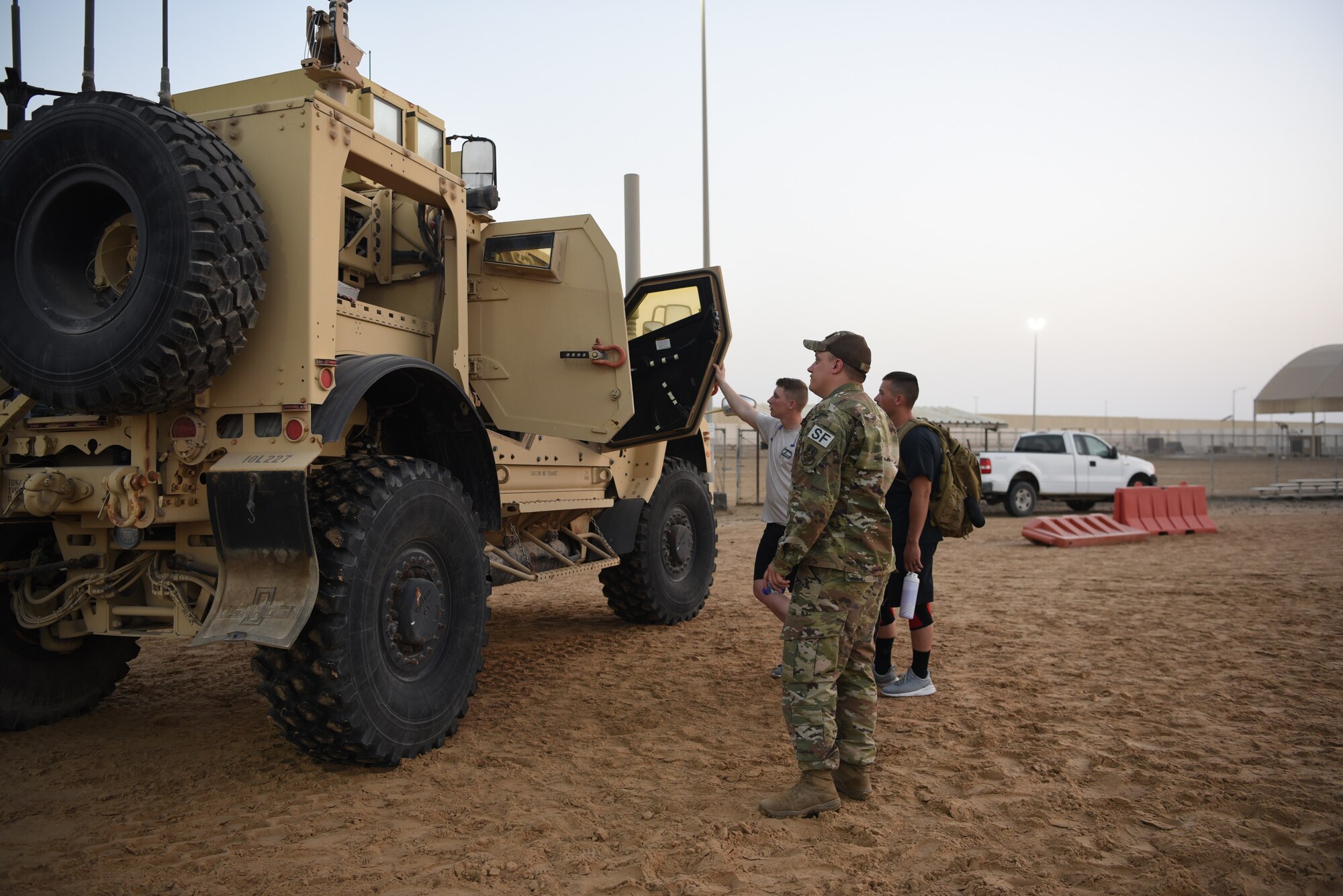 A 380th Expeditionary Security Forces Squadron member answers questions about the Mine Resistant Ambush Protected vehicle displayed during Police Week 2019, May 13, 2019, at Al Dhafra Air Base, United Arab Emirates.