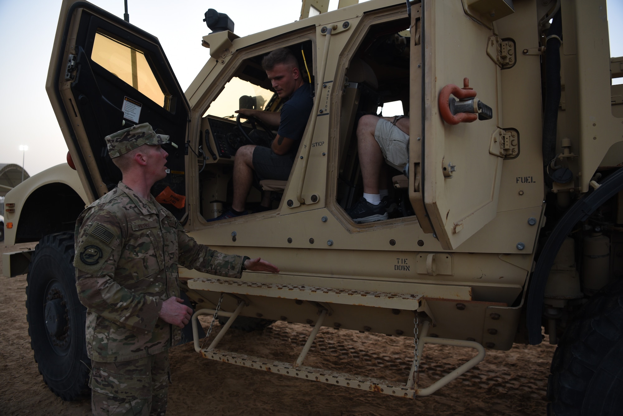 Master Sgt. Sean Fetke, 380th Expeditionary Security Forces training section chief, answers questions about the Mine Resistant Ambush Protected vehicle displayed during Police Week 2019, May 13, 2019, at Al Dhafra Air Base, United Arab Emirates.
