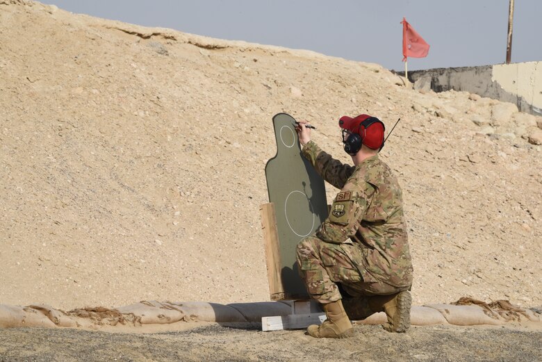 A combat arms instructor, assigned to the 380th Expeditionary Security Forces Squadron, scores a member’s firing during a pistol competition for Police Week 2019, May 13, 2019, at Al Dhafra Air Base, United Arab Emirates.