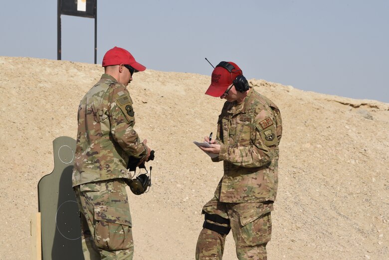 Combat arms instructors, assigned to the 380th Expeditionary Security Forces Squadron, scores a members firing during a pistol competition during Police Week 2019, May 13, 2019, at Al Dhafra Air Base, United Arab Emirates.