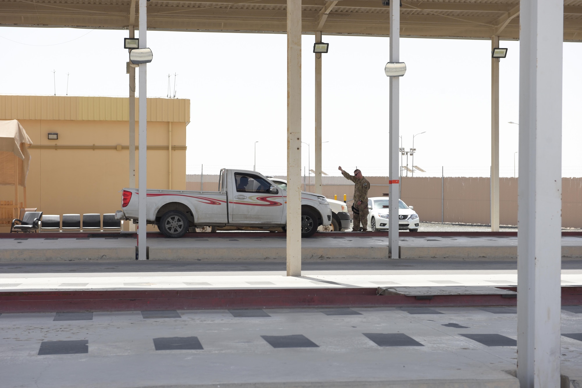 Tech. Sgt. Daniel Becker, 380th Expeditionary Security Forces Squadron defender, brings a car to a halt before inspection May 14, 2019, at Al Dhafra Air Base, United Arab Emirates. Other Country Nationals and their vehicles must be vetted before arriving to the American compounds to ensure the security and safety of the installation. (U.S. Air Force photo by Staff Sgt. Chris Thornbury)