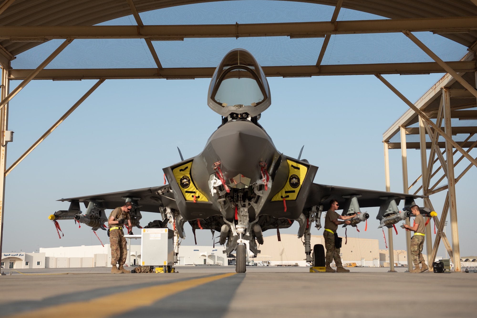 A three-man weapons load team from the 380th Expeditionary Maintenance Group, loads an F-35A Lightning II with a full external loadout at Al Dhafra Air Base, United Arab Emirates, May 2019. F-35As assigned to the 4th Expeditionary Fighter Squadron were configured  with six GBU-49 small glide munitions and two AIM-9x Sidewinder missiles to execute a mission in support of U.S. Forces – Afghanistan. (U.S. Air Force photo by Staff Sgt. Chris Thornbury)