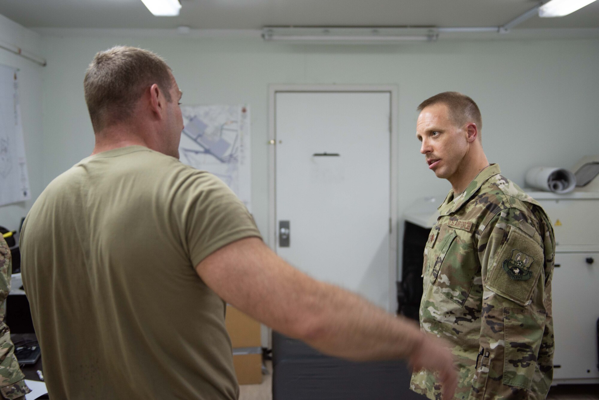 Maj. Adam Frost, 380th Expeditionary Medical Group physical therapist, listens to a patient about his back pain May 17, 2019 at Al Dhafra Air Base, United Arab Emirates. The base physical therapy team went to the maintenance and operations side of the base to visit multiple maintainers on-site. (U.S. Air Force photo by Staff Sgt. Chris Thornbury)