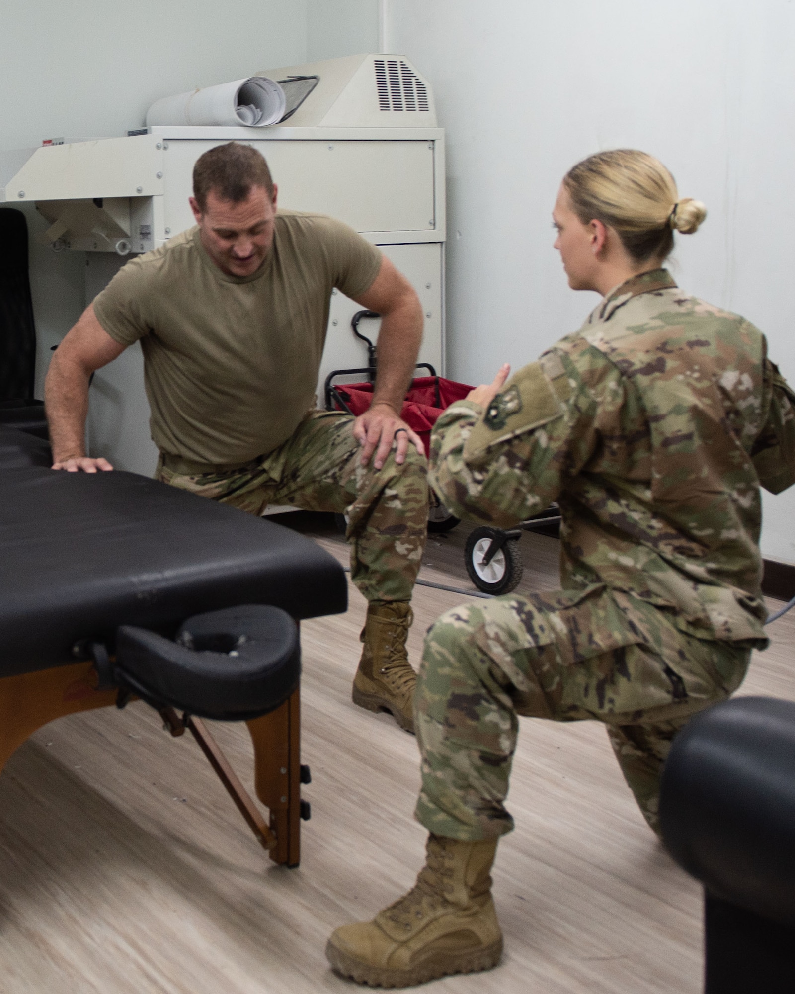 Senior Airman Tanita Frayne, right, 380th Expeditionary Medical Group physical therapist technician, demonstrates a mobility exercise for a patient May 17, 2019 at Al Dhafra Air Base, United Arab Emirates. After a treatment the technician educates the patient on mobility exercises to strengthen the problem area and prevent future injuries. (U.S. Air Force photo by Staff Sgt. Chris Thornbury)