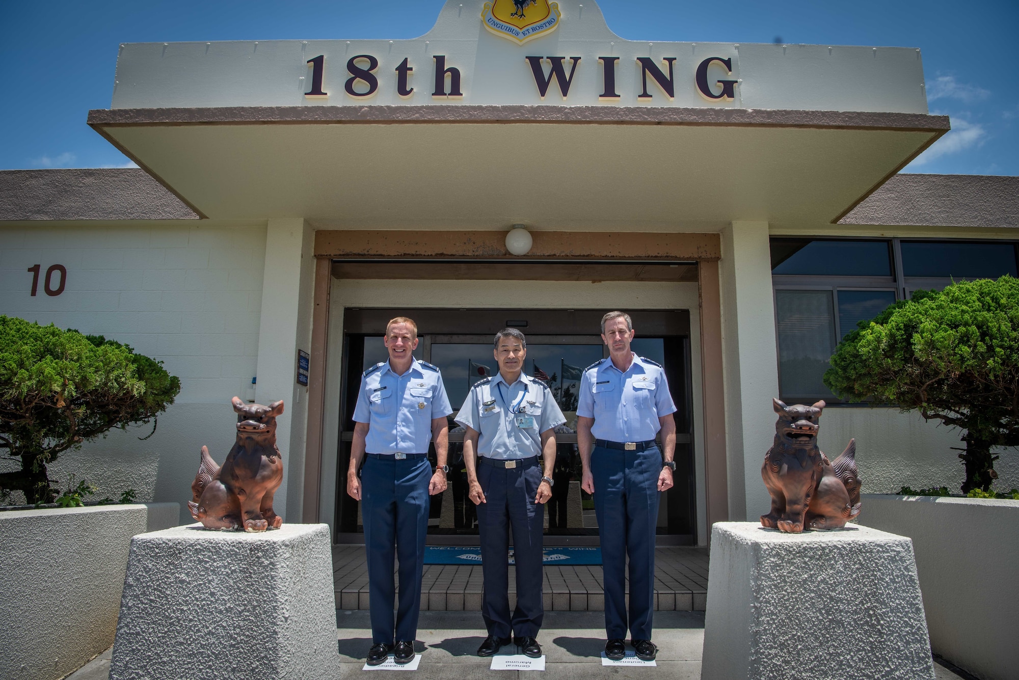 U.S. Air Force Brig. Gen. Case Cunningham, 18th Wing commander (left), Japan Air Self -Defense Force Chief of Staff Gen. Yoshinari Marumo (middle), and Lt. Gen. Kevin B. Schneider, U.S. Air Forces Japan commander, pose for a photo in front of the Kadena Air Base headquarters building, May 21, 2019.
