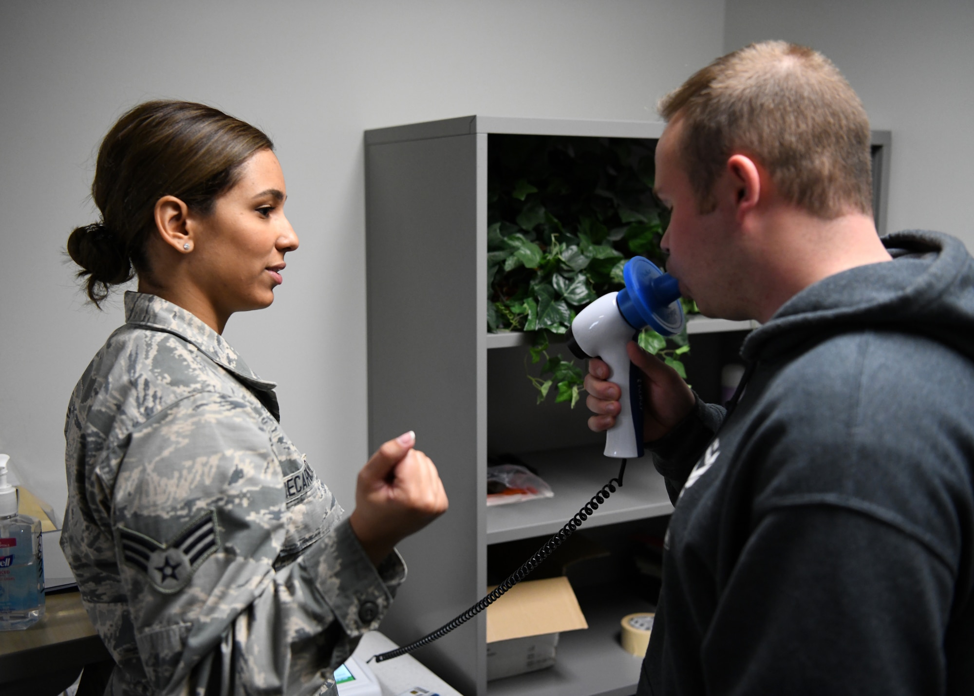 Senior Airman Ana Decarvalho, 104th Medical Group aerospace medical technician, performs a spirometry test with Joe D'Astous, 104th Fighter Wing student flight member at Barnes Air National Guard Base, Massachusetts, May 18, 2019. Decarvalho recently graduated from Quinsigamond Community College's Registered Nurse program. (U.S. Air National Guard photo by Airman 1st Class Randy Burlingame)