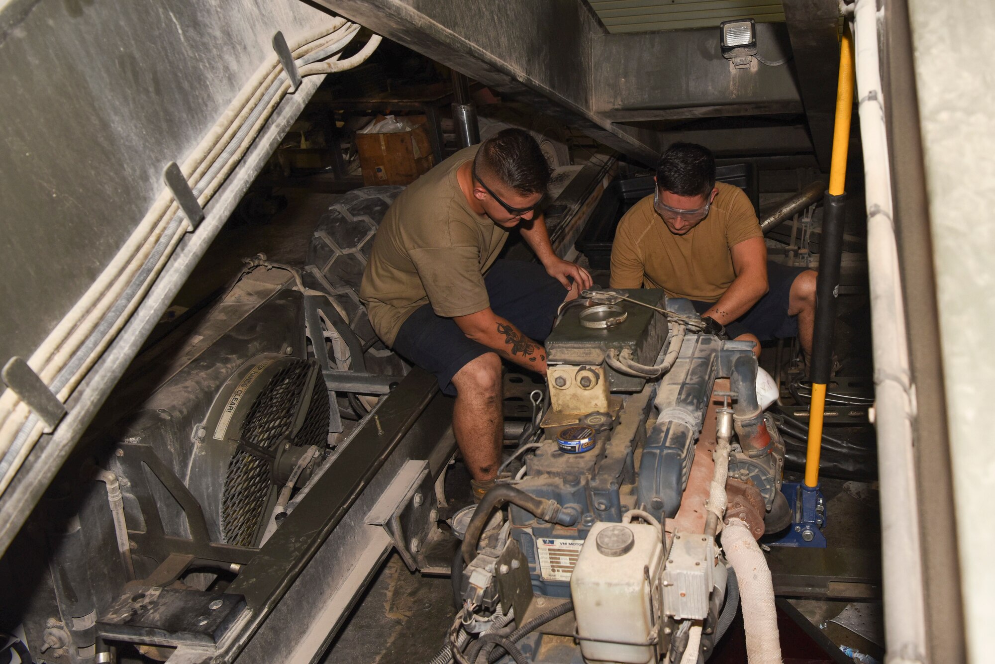 Senior Airman Mathew Wolbert and Senior Airman Timothy Curtis, both 379th Expeditionary Logistics Readiness Squadron material handling equipment maintainers, work on an engine at Al Udeid AB, Qatar, on May 22, 2019. This team ensures our aircraft maintainers have the heavy vehicles they need to tow aircraft, keeps the fuel and fire trucks running and work with vendors to repair leased vehicles.  (U.S. Air Force photo by Staff Sgt. Ashley L. Gardner)