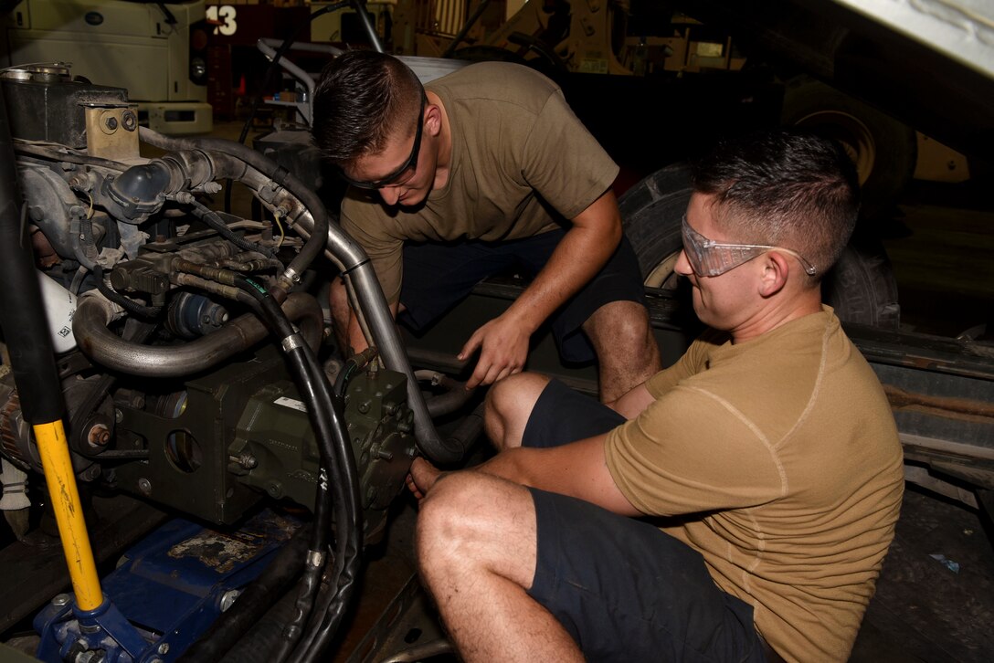 Senior Airman Mathew Wolbert and Senior Airman Timothy Curtis, both 379th Expeditionary Logistics Readiness Squadron material handling equipment maintainers, work on an engine at Al Udeid AB, Qatar, on May 22, 2019. The team works to rectify issues with vehicles that are out of service. (U.S. Air Force photo by Staff Sgt. Ashley L. Gardner)