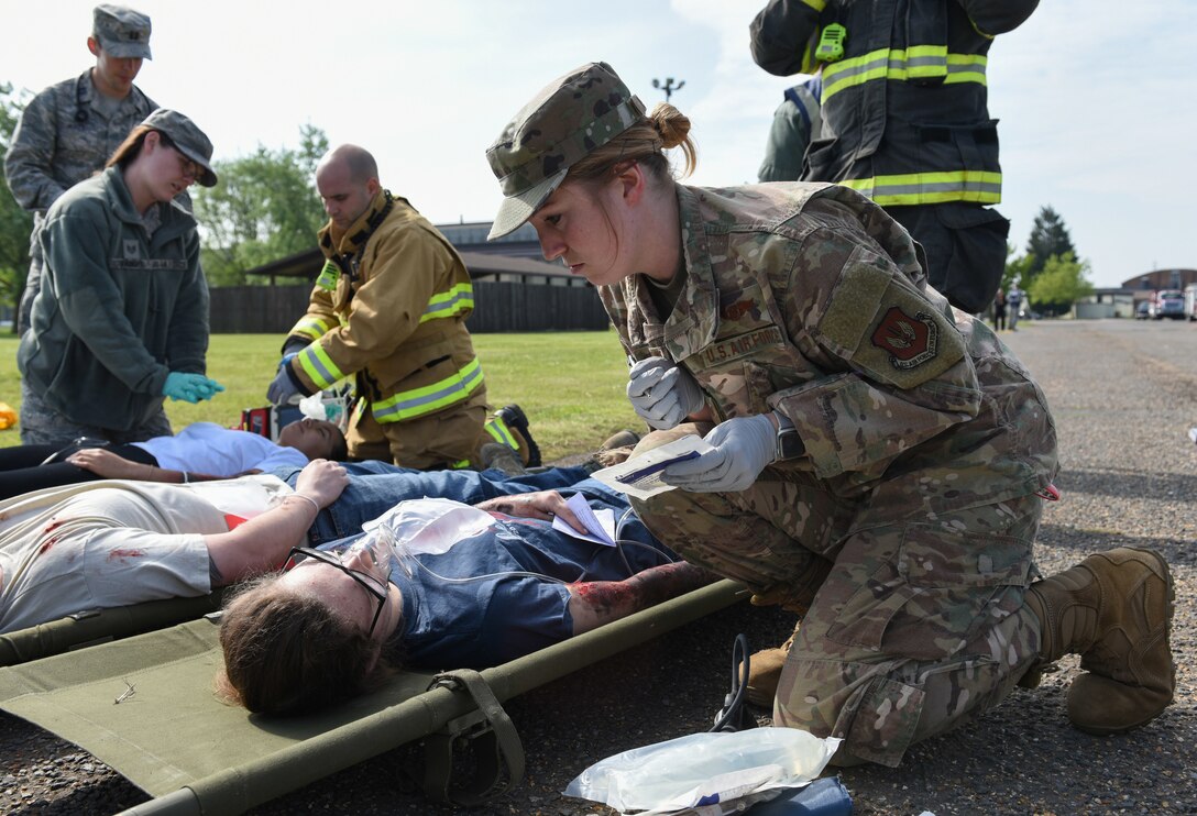 Staff Sgt. Brittani McClure, 423rd Medical Squadron medical technician, assists Sophie Evett, a simulated casualty, during a preparedness exercise at RAF Alconbury, England, May 20, 2019. The exercise tested the 501st Combat Support Wing preparedness and response capabilities to an emergency situation. (U.S. Air Force photo by Airman 1st Class Jennifer Zima)