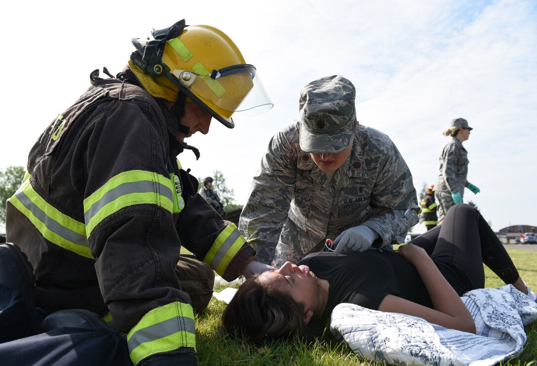 Trevor Butland, 423rd Civil Engineer Squadron firefighter, and Maj. Nicole Molett, 423rd Medical Squadron medical operations flight commander, assist Kennedy Catana, a simulated casualty, during a preparedness exercise at RAF Alconbury, England, May 20, 2019. The exercise tested the 501st Combat Support Wing preparedness and response capabilities to an emergency situation. (U.S. Air Force photo by Airman 1st Class Jennifer Zima)
