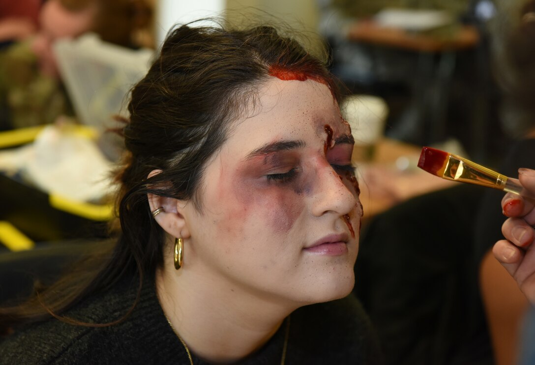 Gabby White, a simulated casualty, receives a mock wound during a preparedness exercise at RAF Alconbury, England, May 20, 2019. The exercise tested the 501st Combat Support Wing preparedness and response capabilities to an emergency situation. (U.S. Air Force photo by Airman 1st Class Jennifer Zima)