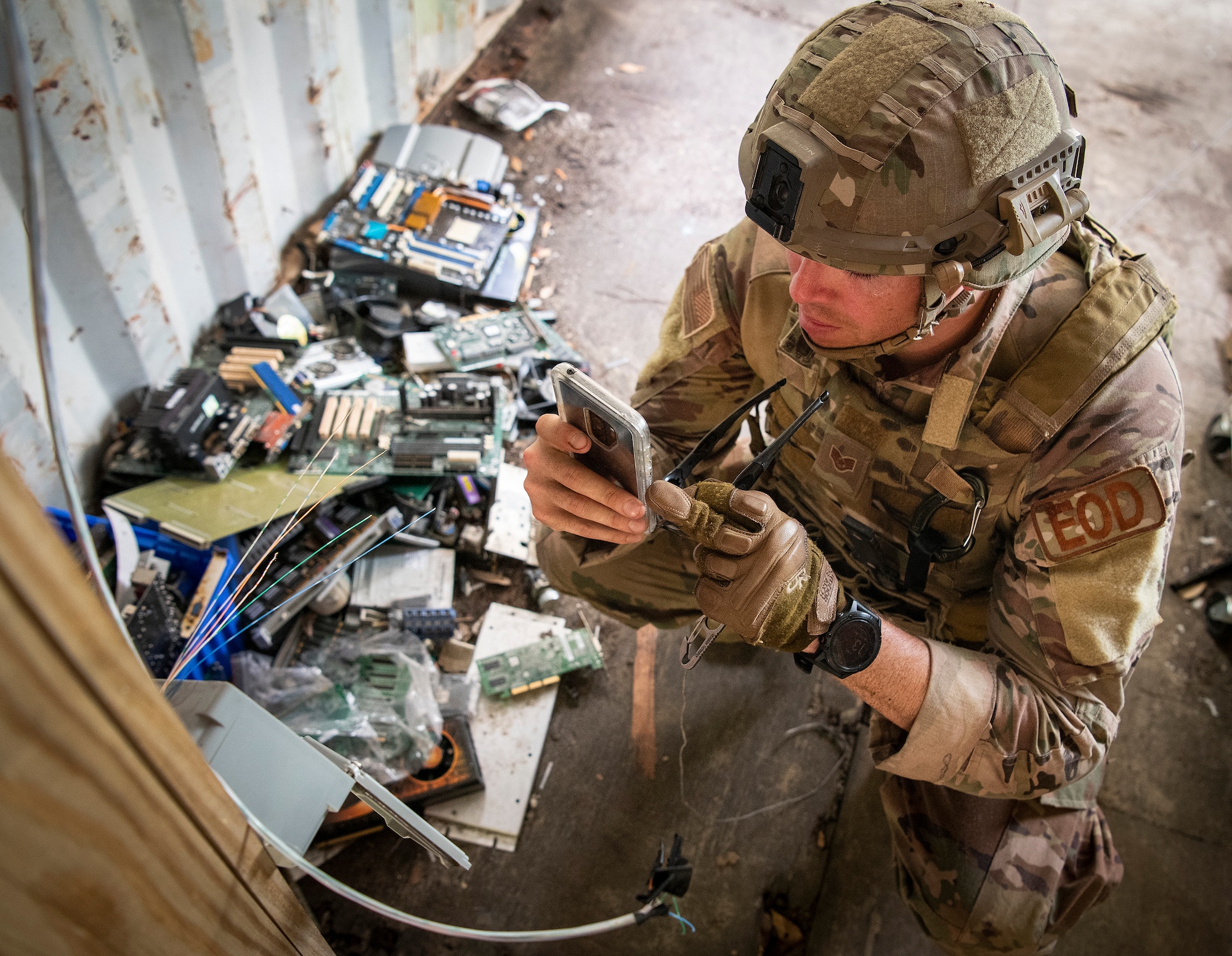 An airman uses his phone to take a photo of an electrical box during the Explosive Ordnance Disposal Warfighter Challenge