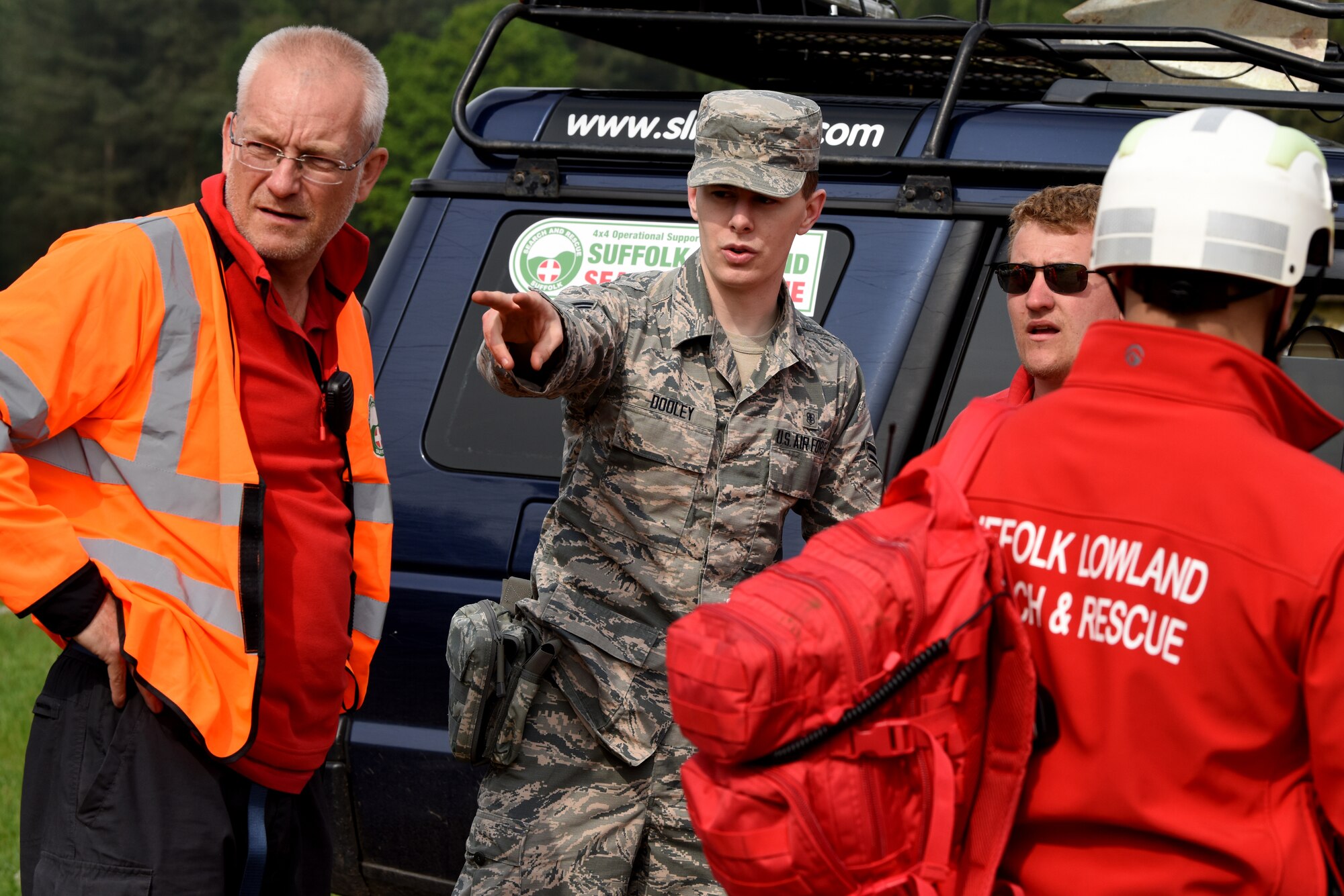 Airman 1st Class Creo Dooley, a 48th Medical Group technician, explains an emergency scenario to local emergency responders, at a British Army training site in Thetford, England, May 19, 2019. Other organizations that partnered with the 48th MDG to perform this training exercise include the Suffolk Police and the Suffolk Accident Rescue Service. (U.S. Air Force photo by Airman 1st Class Madeline Herzog)