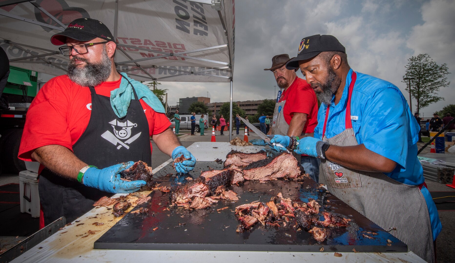 Volunteers prepare brisket at the Operation BBQ Relief event at Brooke Army Medical Center, Joint Base San Antonio-Fort Sam Houston, May 20. Volunteers provided 8,000 meals for BAMC staff, patients and family members during the event.