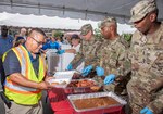 Brig. Gen. George N. Appenzeller, Brooke Army Medical Center commanding general; Command Sgt. Major Thomas Oates, BAMC command sergeant major; and Sgt. Major James Brown, chief clinical sergeant major, serve lunch to BAMC staff, patients and family members during the Operation BBQ Relief event at Brooke Army Medical Center at Joint Base San Antonio-Fort Sam Houston May 20. Volunteers provided 8,000 meals during the event.