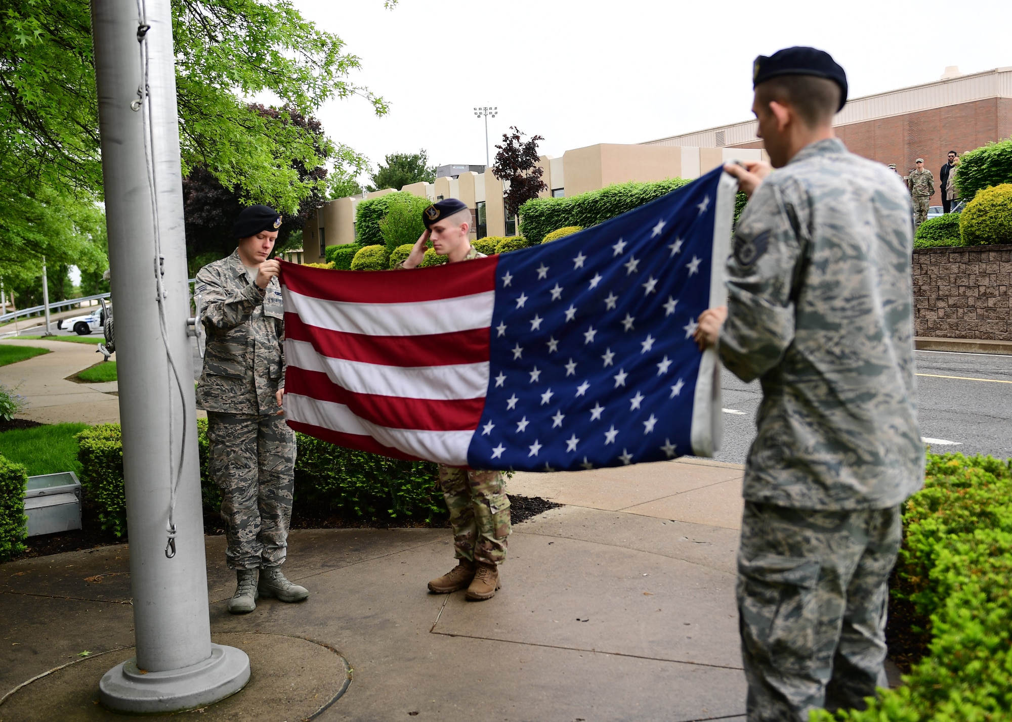 Staff Sgt. Berl Stinson, Senior Airmen Jeremy Freeland and Michael Beatty, members of the 911th Security Forces Squadron, perform a flag folding ceremony at the Pittsburgh International Airport Air Reserve Station, Pennsylvania, May 13, 2019. The flag ceremony kicked off the Law Enforcement Week celebrations that the 911th SFS hosted throughout the week. (U.S. Air Force photo by Senior Airman Grace Thomson)