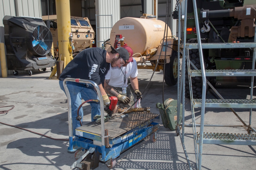 Contractors attached a hook and pulley system to a Medium Tactical Vehicle Replacement as part of the final installation process at the Motor Transportation Branch at Production Plant Barstow, Marine Depot Maintenance Command aboard Marine Corps Logistics Base Barstow, Calif., May 9.