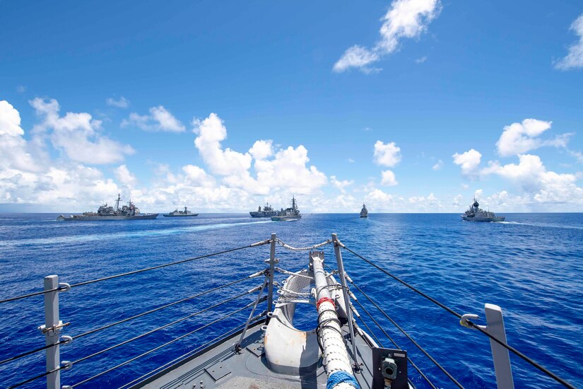 A group of ships travel in waters.