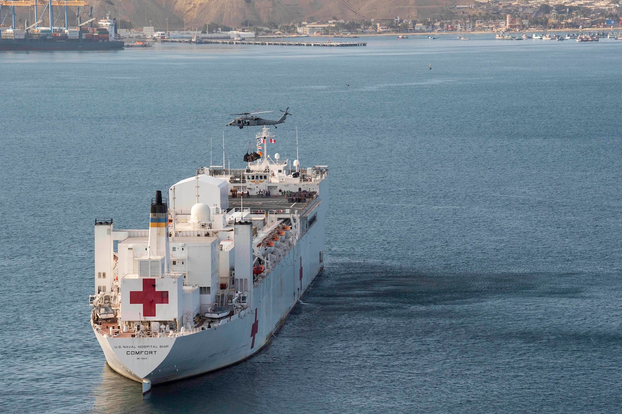 A U.S. navy ship receives medical supplies from a helicopter.