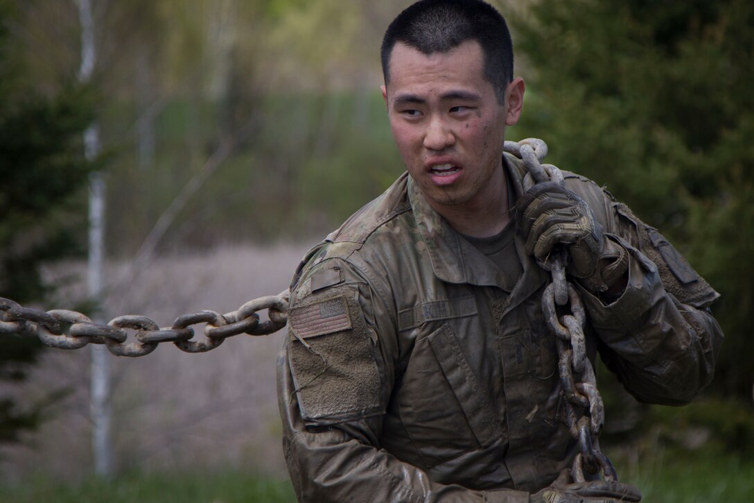 A soldier carries a chain over his shoulder.