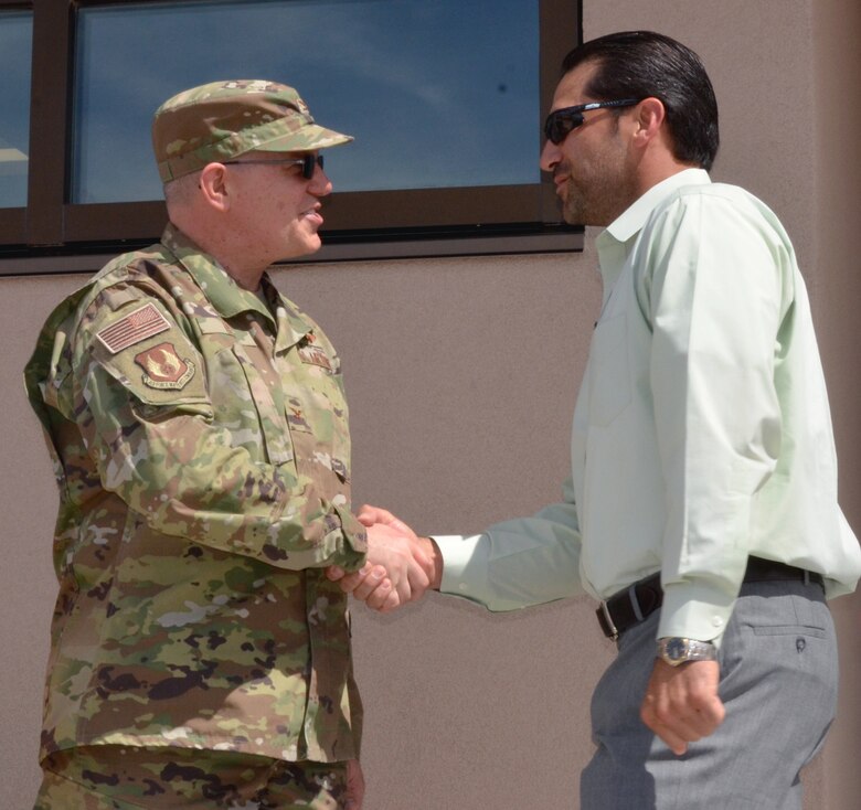 Filemon Gallegos, project manager, USACE, receives a commander’s coin from Col. Eric J. Felt, commander, Space Vehicles Directorate, during the NTSIL ribbon-cutting ceremony at KAFB on March 26, 2019.