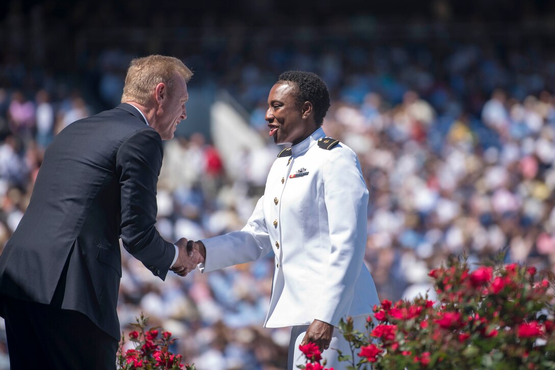 Acting Defense Secretary Patrick M. Shanahan shakes hands with a sailor at a ceremony.