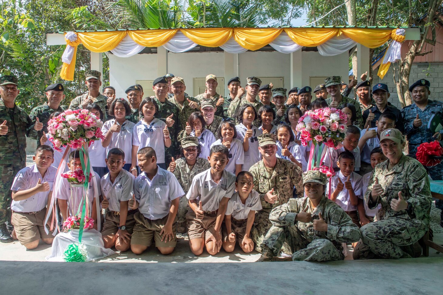 CHON BURI PROVINCE, Thailand (May 25, 2019) Pacific Partnership 2019 leaders, U.S. Navy Sailors assigned to Amphibious Construction Battalion (ACB) 1, members of the Royal Thai Armed Forces and children who attend the Ban Mabfugthong School pose for a photo during the ribbon cutting ceremony that marks the completion of the new restroom facility at the school during Pacific Partnership 2019. The scope of the project included construction of a four-stall restroom, which will provide additional facilities for students to use during school and for local community gatherings held at the facility. Pacific Partnership, now in its 14th iteration, is the largest annual multinational humanitarian assistance and disaster preparedness mission conducted in the Indo-Pacific. Each year, the mission team works collectively with host and partner nations to enhance regional interoperability and disaster response capabilities, increase stability and security in the region, and foster new and enduring friendships across the Indo-Pacific.