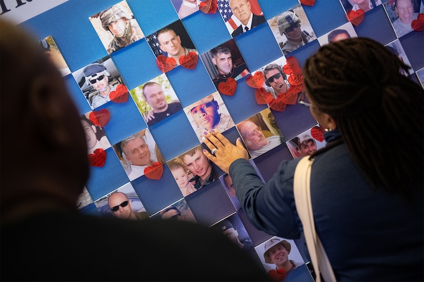 People look at and touch a display of pictures.