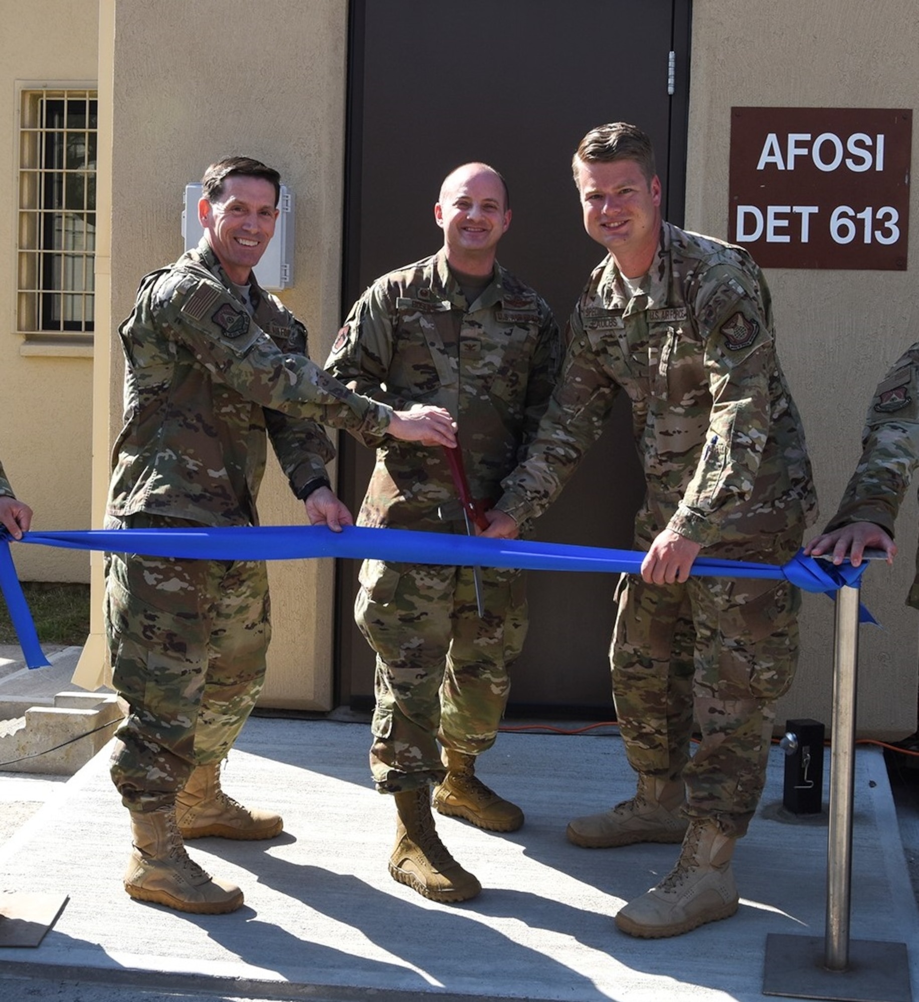 Perseverance paid off for OSI Detachment 613, Kunsan Air Base, Republic of Korea. After 18 months of planning, renovating and working in other workspaces around the base, the det returned to its fully renovated facility following a ribbon cutting ceremony May 23, 2019. Conducting ribbon cutting are, left to right, Col. Dave Patterson, AFOSI 6th Field Investigations Region vice commander, Col. John Bosone, 8th Fighter Wing commander, and Special Agent Dustin Paulus, AFOSI Det. 613 commander. (U.S. Air Force photo by Staff Sgt. Mackenzie Mendez)