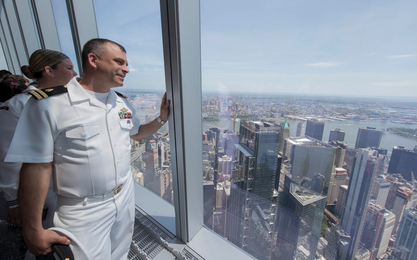 Fleet Week 2019, naval officer looks out window of skyscraper.