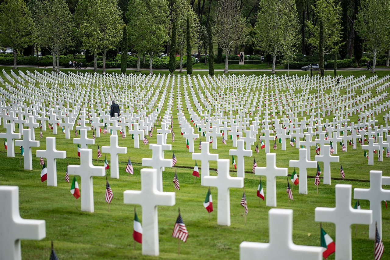 A man walks among tombstones.