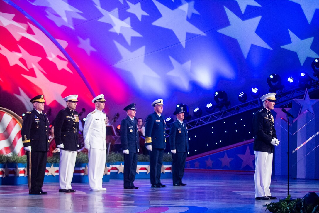 A general and officers stand on stage at a Memorial Day concert.