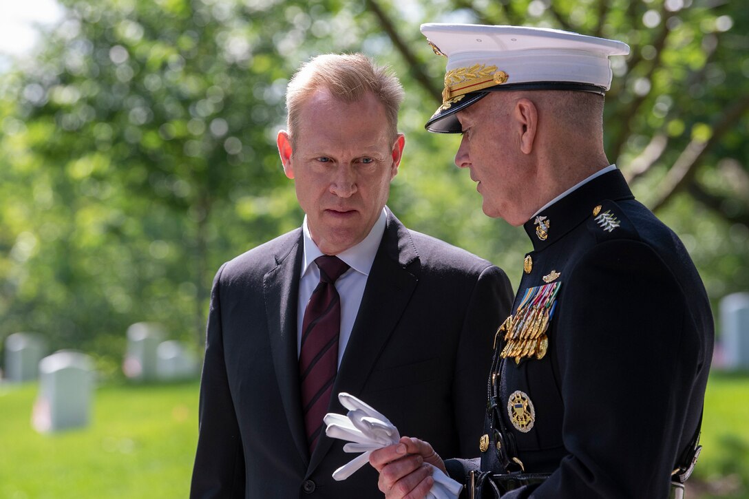Two men talk before a ceremony.