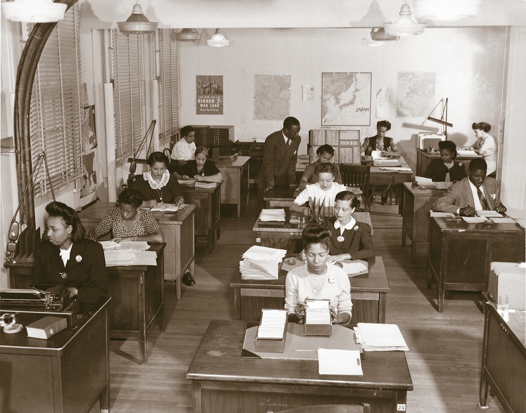 A segregated office during WWII. William Coffee, standing, was the first African American supervisor in the Army