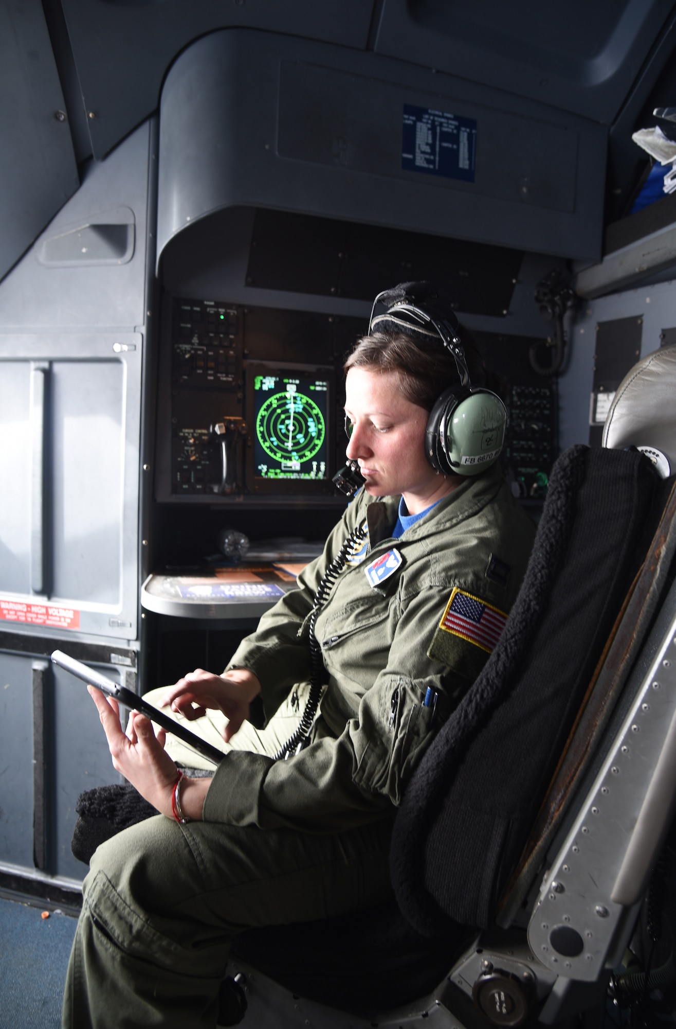 Capt. Julie Fantaske, 53rd Weather Reconnaissance Squadron navigator, checks her inflight publications on her tablet on a flight from Brunswick, Georgia to Keesler Air Force Base, Mississippi, May 10, 2019.  Navigators are responsible for preparing flight plans, which include routes, headings, checkpoints, and times. During flight, they operate from their station using equipment such as GPS, radio, and radar systems that assists in guiding the aircraft through weather. (U.S. Air Force photo by Tech. Sgt. Christopher Carranza)
