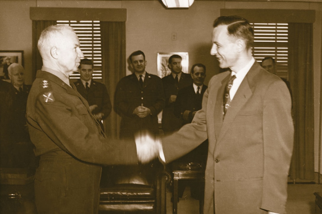 NSA Director Lieutenant General Ralph J. Canine, USA, shakes hands with Louis W. Tordella