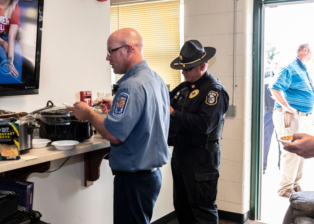 Firefighter and Police Officer place chili in their bowls