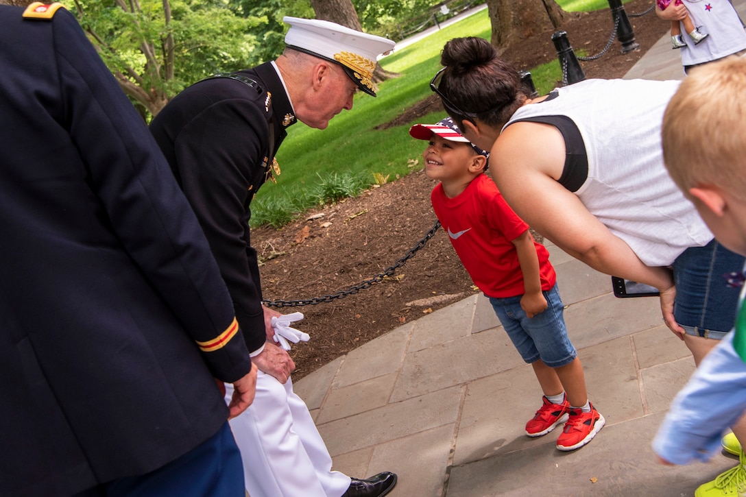 Marine Corps Gen. Joe Dunford talks to a child while his family looks on.