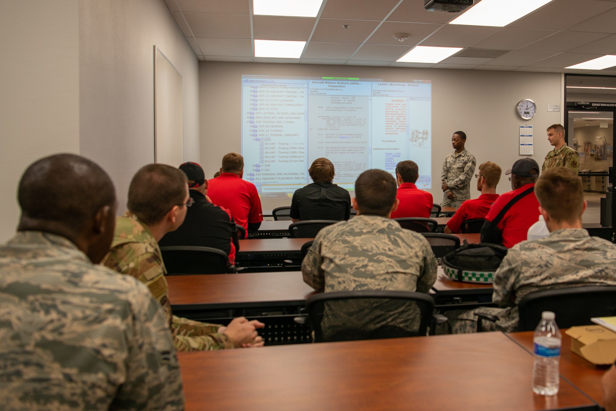 Airmen assigned to the 309th Aircraft Maintenance Unit brief employees of the Phoenix-Mesa Gateway Airport, May 21, 2019, in Mesa, Ariz.