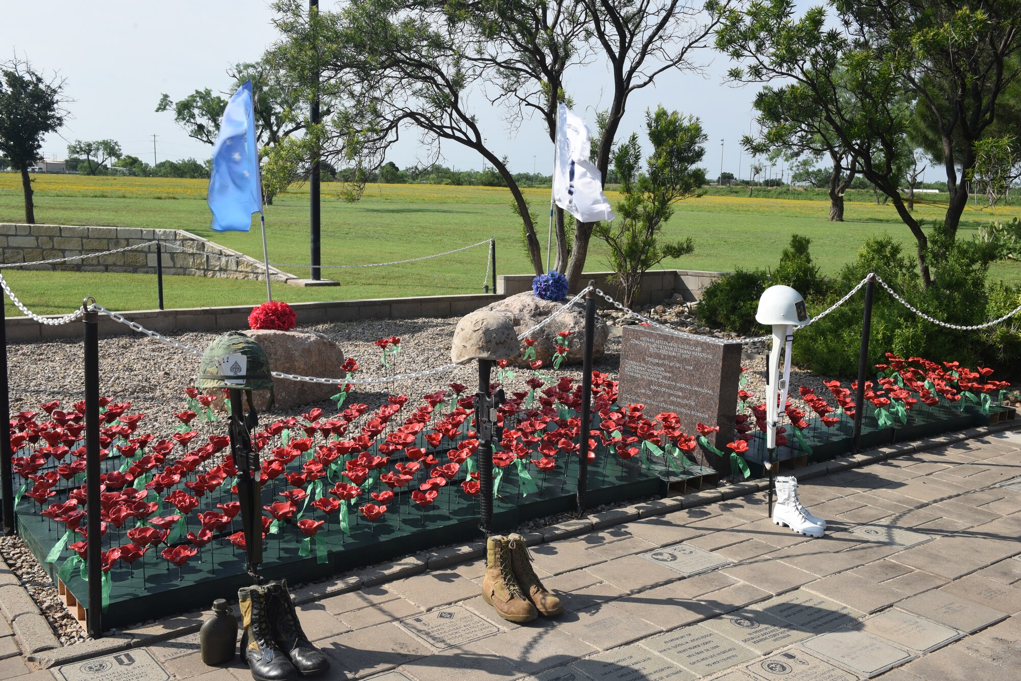 Boots, rifles, helmets and poppies are on display at the Concho Valley Vietnam Veterans Memorial during the Vietnam Veterans Memorial Day Ceremony in San Angelo, Texas, May 27, 2019. The different boots and helmets each represent a different war and the poppy is a reminder to never forget those who sacrificed for freedom. (U.S. Air Force photo by Airman 1st Class Zachary Chapman/Released)