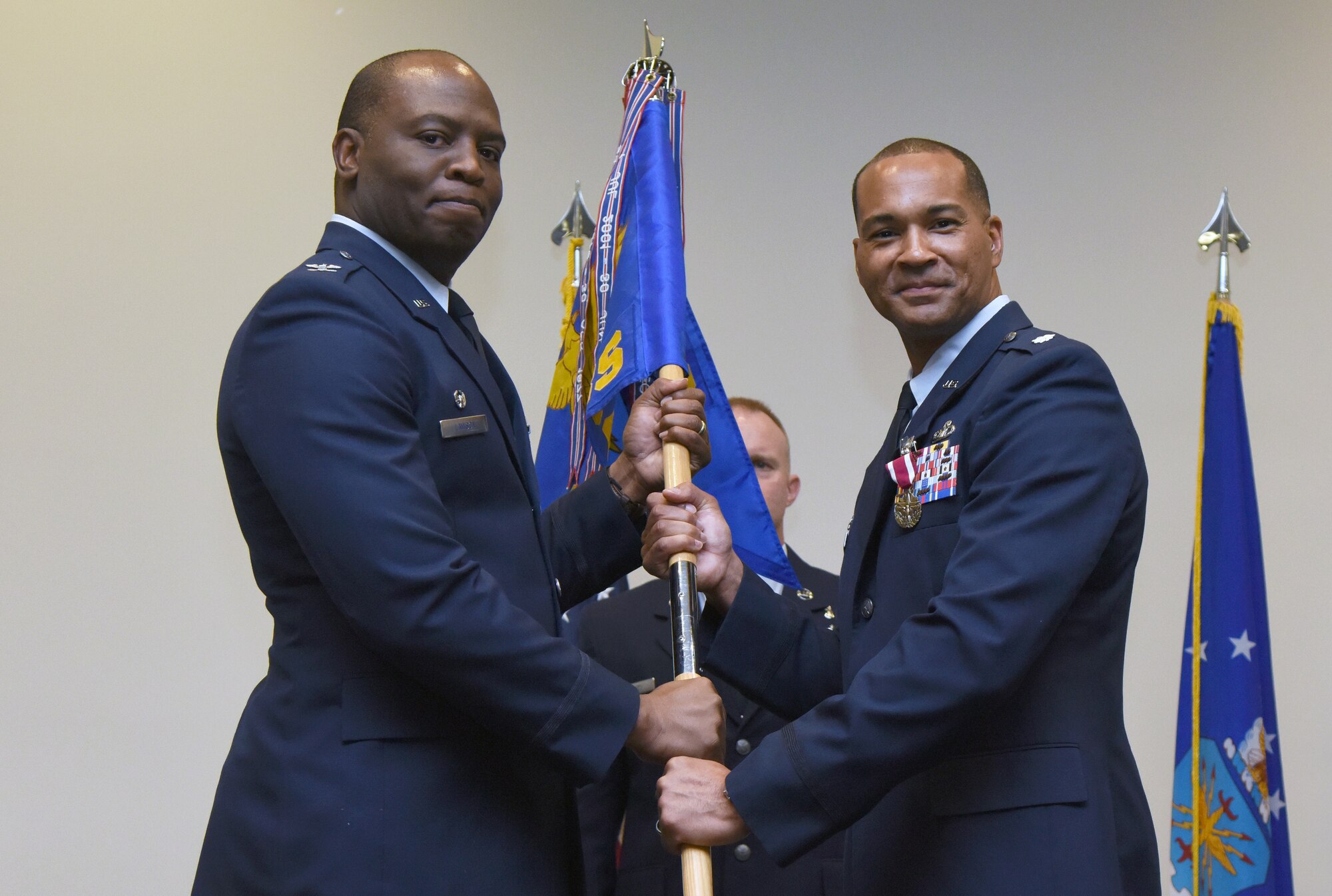 U.S. Air Force Col. Leo Lawson Jr., 81st Training Group commander, takes the 334th Training Squadron guidon from Lt. Col. Billy Wilson, Jr., outgoing 334th TRS commander, during the 334th TRS change of command ceremony in the Roberts Consolidated Aircraft Maintenance Facility at Keesler Air Force Base, Mississippi, May 23, 2019. The passing of the guidon is a ceremonial symbol of exchanging command from one commander to another. (U.S. Air Force photo by Kemberly Groue)