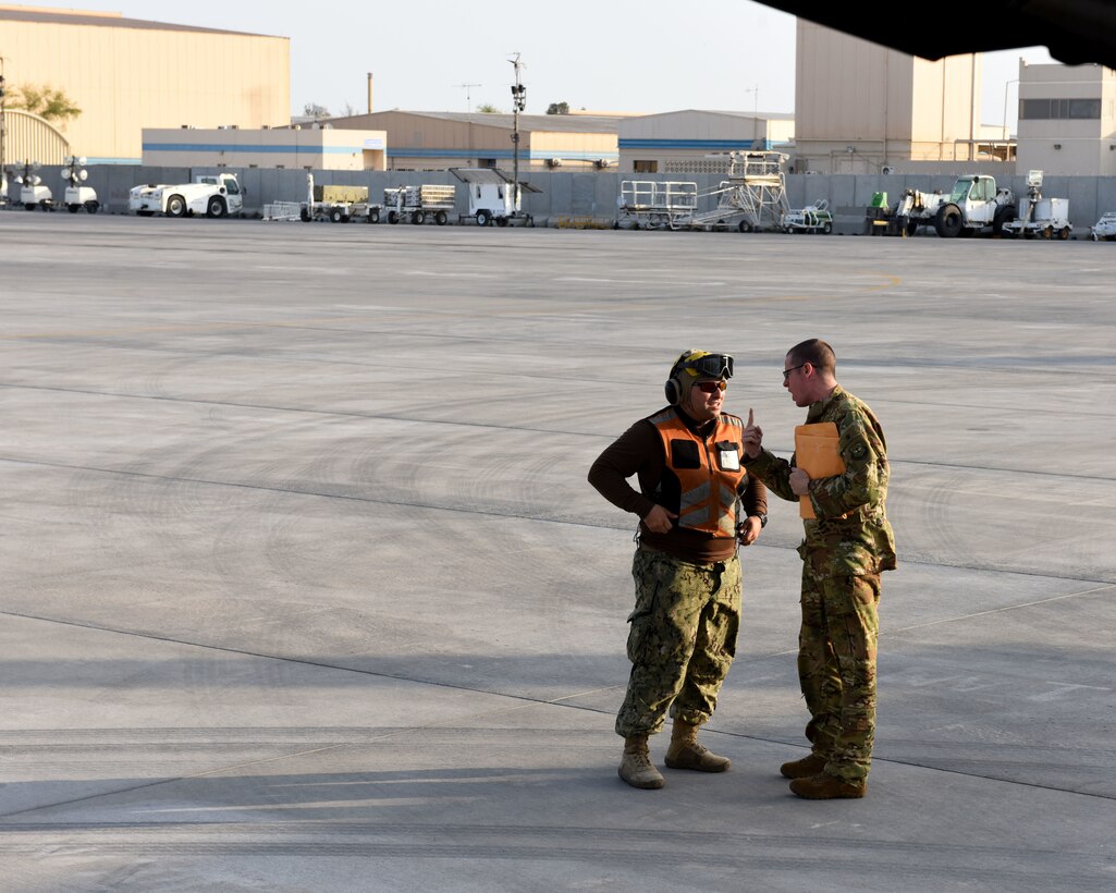 U.S. Air Force Capt. Justin Poole, 21st Airlift Squadron pilot, talks with a U.S. Navy sailor outside a C-17 Globemaster III May 19, 2019, at an undisclosed location. The C-17 is capable of rapid strategic delivery of troops and cargo anywhere in the world. (U.S. Air Force photo by 2nd Lt. R. Michael Longoria)