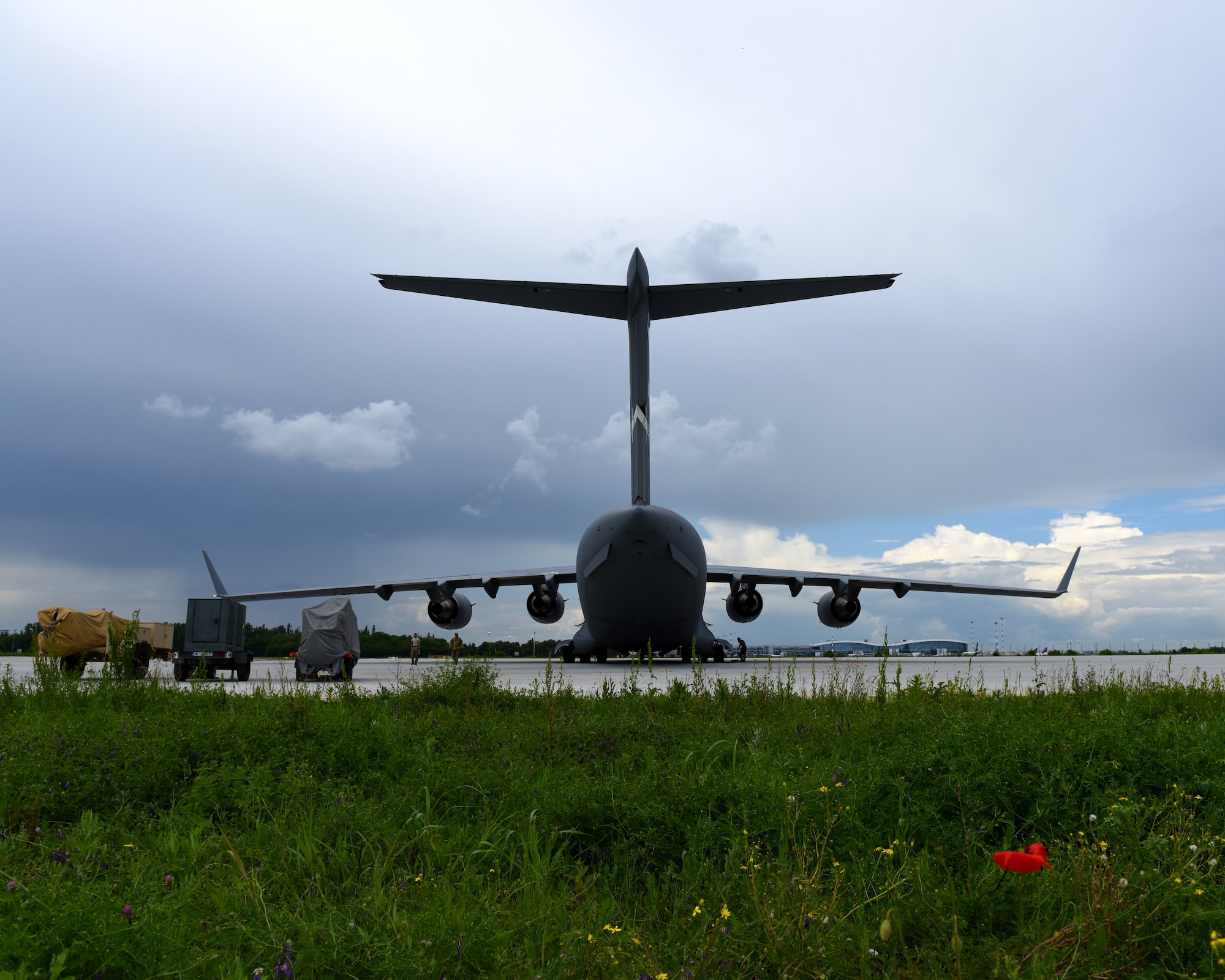 A C-17 Globemaster III from the 60th Air Mobility Wing is parked near the flightline at the Henri Coanda International Airport May 25, 2019, in Bucharest, Romania. U.S. Air Force personnel worked with members of the Romanian armed forces to load the C-17 with cargo and equipment that would then be delivered to Afghanistan in support of NATO’s Resolute Support mission. Romania is the sixth largest contributor of troops to RS with more than 730 personnel deployed. (U.S. Air Force photo by 2nd Lt. R. Michael Longoria)