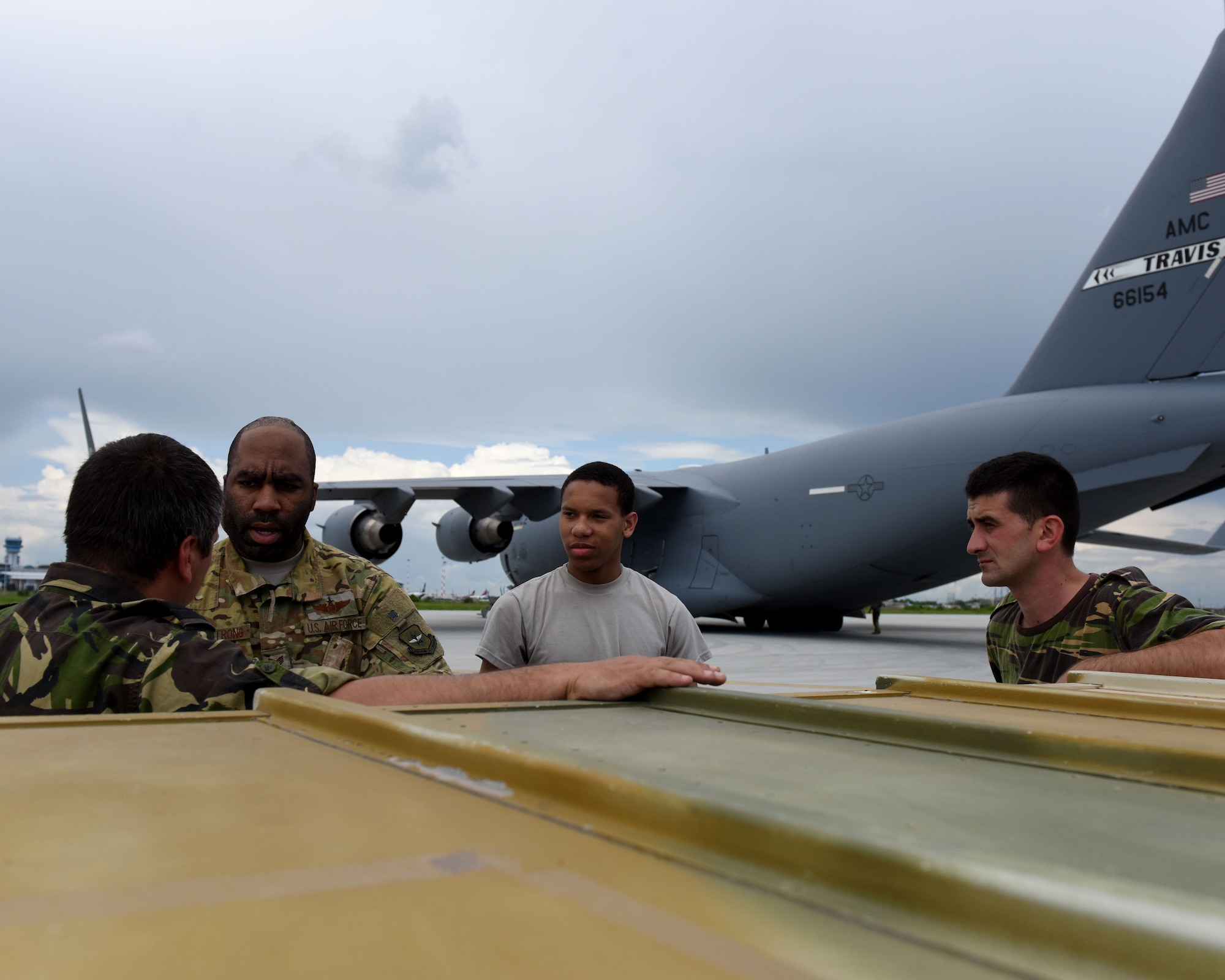 U.S. Air Force Staff Sgt. James Armstrong and Airman 1st Class Alan Collier, both center, 21st Airlift Squadron loadmasters, talk with Romanian armed forces personnel about C-17 Globemaster III aircraft loading requirements May 25, 2019, in Bucharest, Romania. With more than 730 personnel deployed to Afghanistan, Romania is the sixth largest contributor of troops to NATO’s Resolute Support train, advise and assist mission. (U.S. Air Force photo by 2nd Lt. R. Michael Longoria)