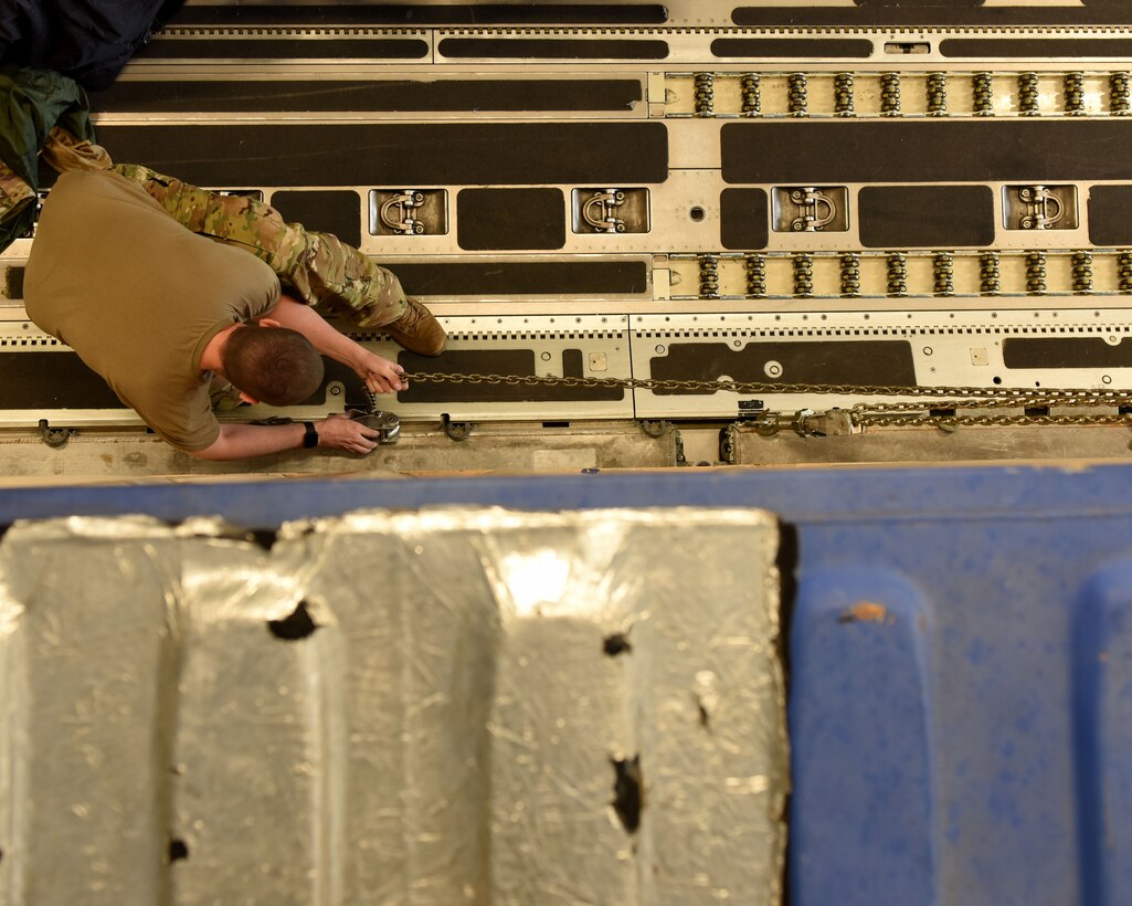 U.S. Air Force Capt. Justin Poole, 21st Airlift Squadron pilot, helps loadmasters chain down a cargo container on a C-17 Globemaster III May 25, 2019, in Bucharest, Romania. With more than 730 personnel deployed to Afghanistan, Romania is the sixth largest contributor of troops to NATO’s Resolute Support Mission. (U.S. Air Force photo by 2nd Lt. R. Michael Longoria)
