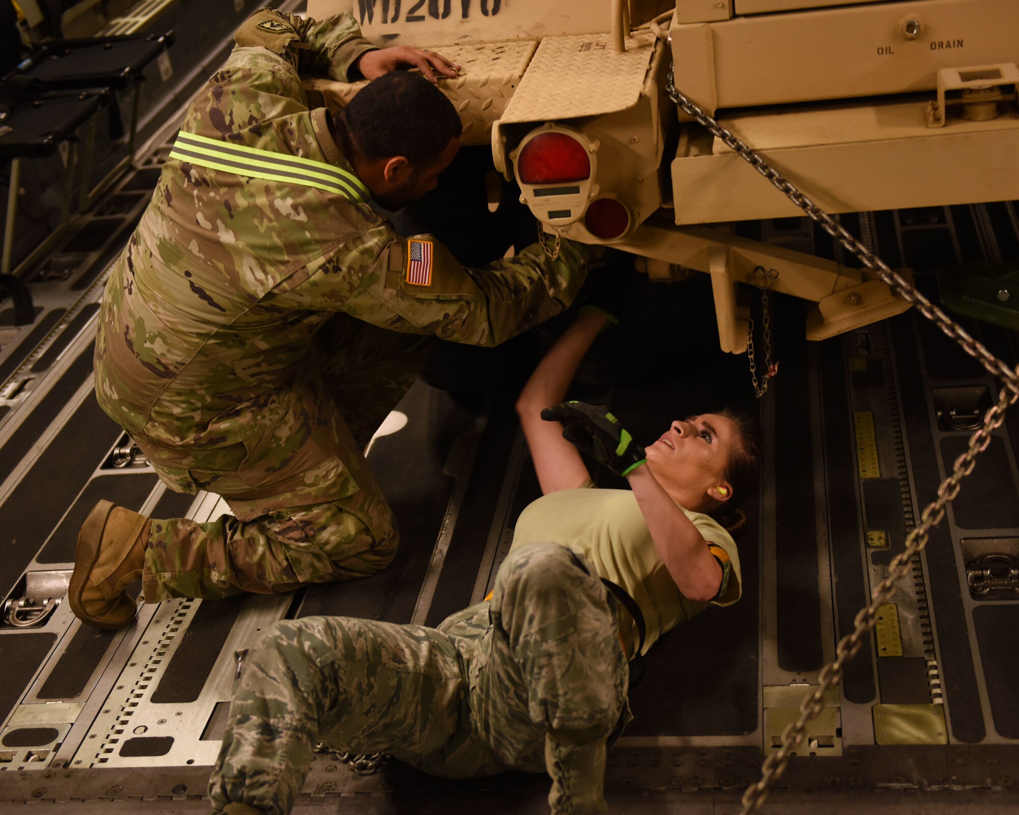 A U.S. Air Force Airman and a U.S. Army Soldier secure a truck to the cargo floor of a C-17 Globemaster III from the 60th Air Mobility Wing May 17, 2019, at Pope Army Air Field, North Carolina. The C-17 is capable of rapid strategic delivery of troops and cargo anywhere in the world. (U.S. Air Force photo by 2nd Lt. R. Michael Longoria)