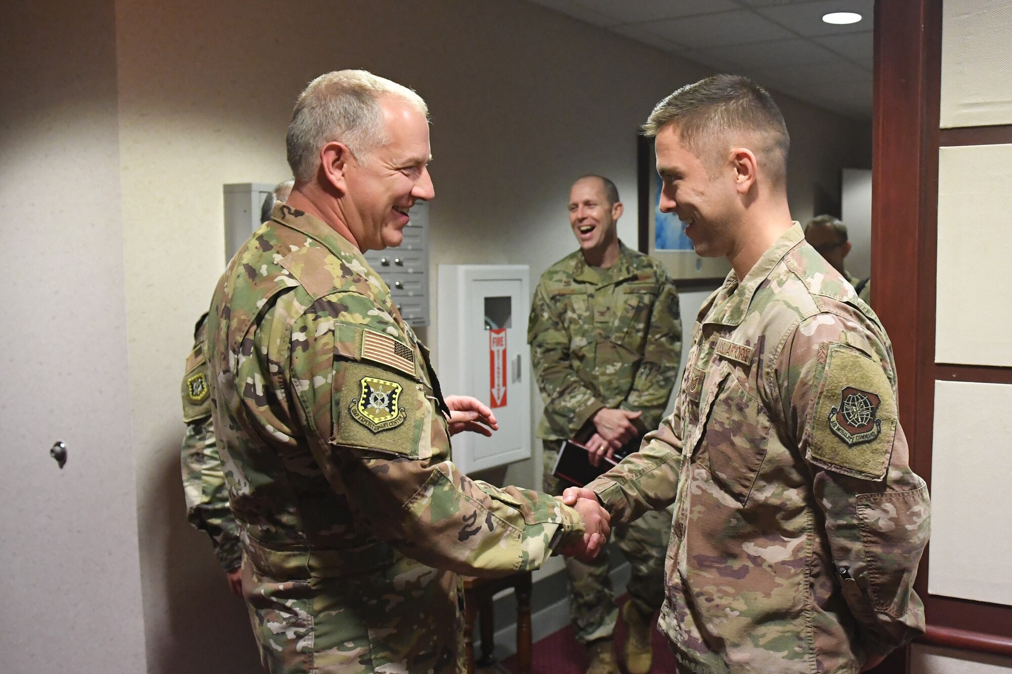 Maj. Gen. John Gordy, U.S. Expeditionary Center commander, left, presents a coin to Tech. Sgt. Jeff Marston, 821st Contingency Response Group quality assurance chief inspector, in recognition of his superior performance during a visit to Travis Air Force Base, California, May 21, 2019. During the visit, Airmen briefed the capabilities of their unit and showcased innovation projects. The 621st CRW is a unique bicoastal unit highly-specialized in training and rapidly deploying personnel to quickly open airfields and establish, expand, sustain and coordinate air mobility operations. (U.S. Air Force photo by Tech. Sgt. Liliana Moreno)